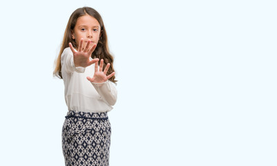 Brunette hispanic girl afraid and terrified with fear expression stop gesture with hands, shouting in shock. Panic concept.