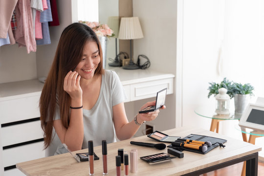 Asian young female blogger recording vlog video with makeup cosmetic at home online influencer on social media concept.live streaming viral.