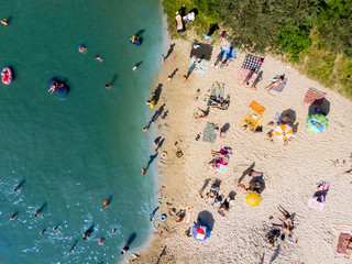 LVIV, UKRAINE - 9 JUNE, 2018: people sunbathing, swimming, resting at sand beach near lake. aerial view © phpetrunina14