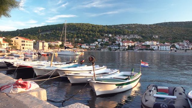 Small fishing village in Croatia, traditional fishing boats in harbor, Vinjerac near Zadar, pan left to right