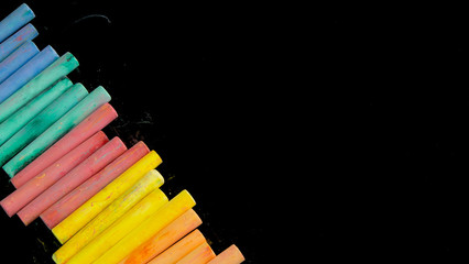 Obraz premium Multi color chalks on black background for copy space