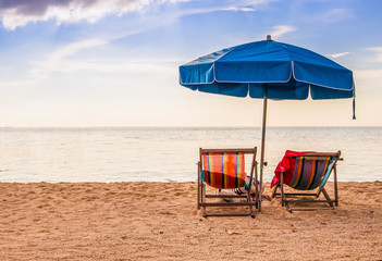 Couple Beach chair  and umbella on a tropical beach at island,couple on island vacation holiday relax the sun on their deck chairs under a beach umbrella in thailand