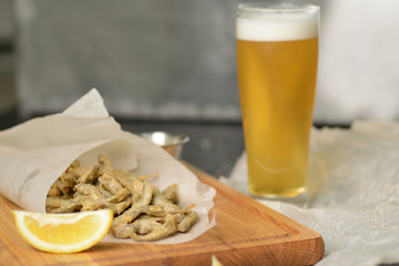 fried fish in a paper bag on a wooden board