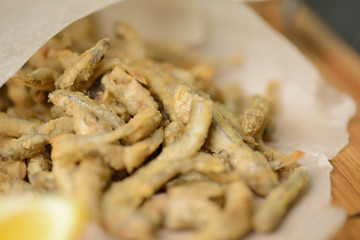 fried fish in a paper bag on a wooden board