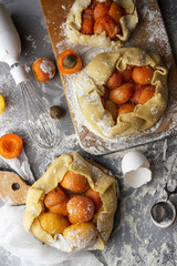 The process of cooking apricot pie. Fruits in a dough, flour. Flat lay. Working conditions in the kitchen. Galette