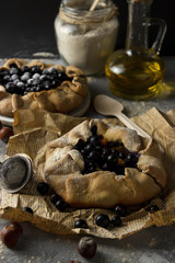 Pies with black currant on kraft paper. Galette. Gray background