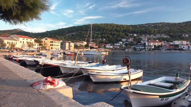 Small fishing village in Croatia, traditional fishing boats in harbor, Vinjerac near Zadar, pan left to right
