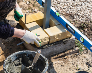 The worker lays bricks on the construction site