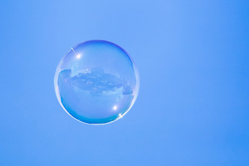 Soap bubbles in flight against the blue sky