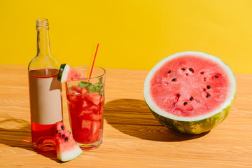 close up view of fresh watermelon and watermelon drink on wooden surface on yellow background