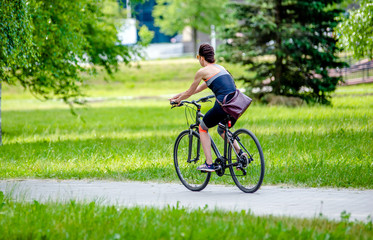 Obraz premium Girl riding a bike in the city Park 