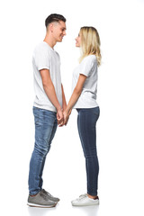 side view of smiling couple holding hands and looking at each other isolated on white