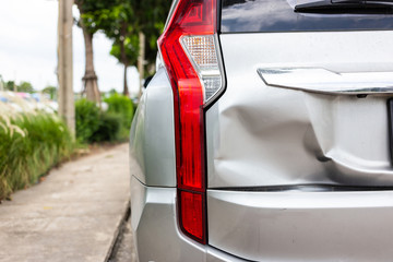 A car has a dented rear bumper after an accident,Backside of new silver car get damaged - obrazy, fototapety, plakaty