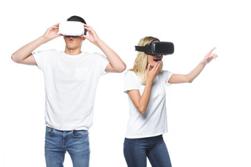 surprised couple using virtual reality headsets isolated on white