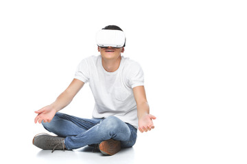 handsome man in virtual reality headset showing shrug gesture isolated on white