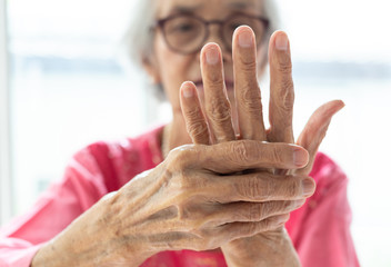 Elderly woman suffering from pain in hand,arthritis,beriberi - obrazy, fototapety, plakaty