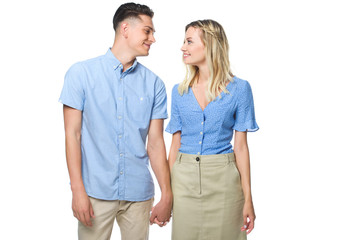 happy young couple holding hands and looking at each other isolated on white