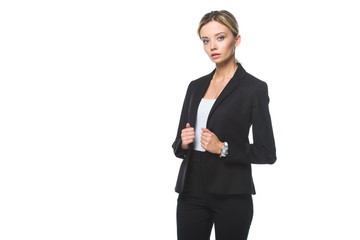 serious young businesswoman in stylish black suit looking at camera isolated on white