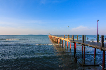 Concrete jetty into the sea on blue sky background