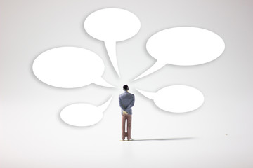 One miniature businessman text balloon graphic back view.