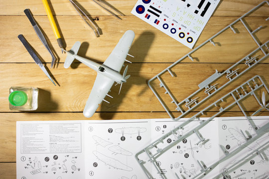 Scale model WW2 fighter plane building on wooden table with scale modelling tools.