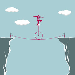 The businessman is riding a wheelbarrow on the steel wire. Stunt show.