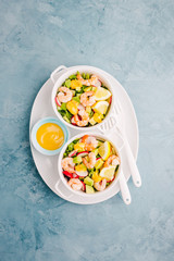 Salad with prawns in bowls on table