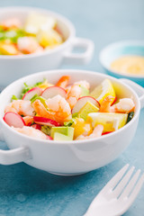 Salad with prawns in bowls on table