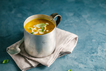 Tasty creamy pumpkin soup in mug