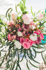 Wedding bouquet in Boho style with pink silk ribbons, roses, chrysanthemum and tropical plants