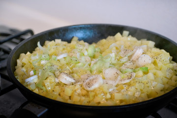 Fried potato with onion in a frying pan. Roasted potatoes.