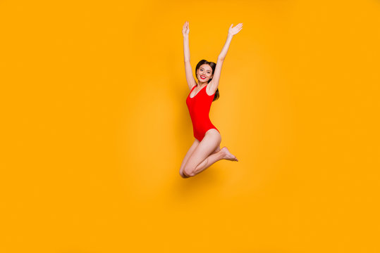 Freedom restless concept. Full-size portrait of excited girl with rise up hands jumping up isolated on yellow background