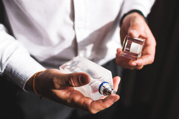 Man holding bottle of perfume and smells fragrance - 215781153