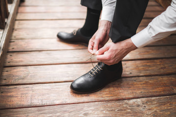 Man wearing brown leather classic shoes, black trousers and white shirt, business style