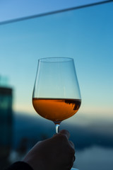 person holding a drink glass with blue sky background