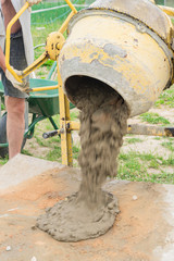 construction worker poors concrete out of  concrete mixer. process of creating cement on the...