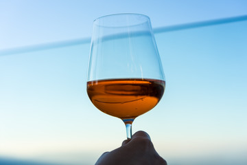 wine glass with drink in front of blue lake iconic background