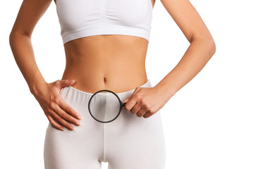 Woman holding magnifying glass over her abdomen 