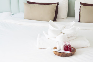 Fototapeta na wymiar Hotel towel set with toothbrush and toothpaste on white bed