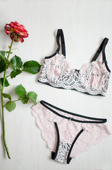 Sexy panties and bra set pink and black color on yhe white background. Lace lingerie with flower.