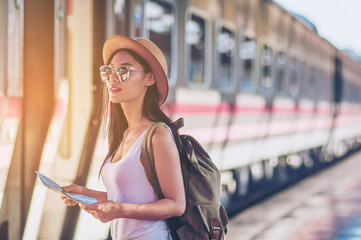 Obraz premium Tourist travel woman looking at the map while walking at train station - street backpack travel concept