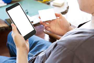 man holding credit card and using mobile smart phone for online shopping