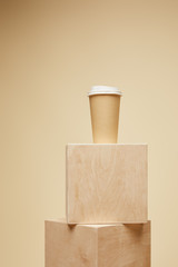 disposable coffee cup on wooden cubes isolated on beige