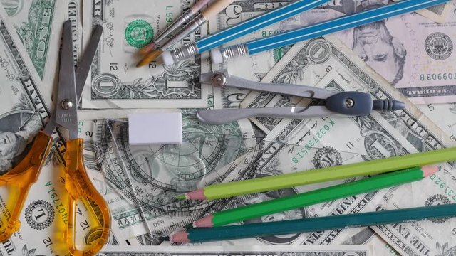 high school expenses, concept, pencils on money, dollars, rotating, turning, from above