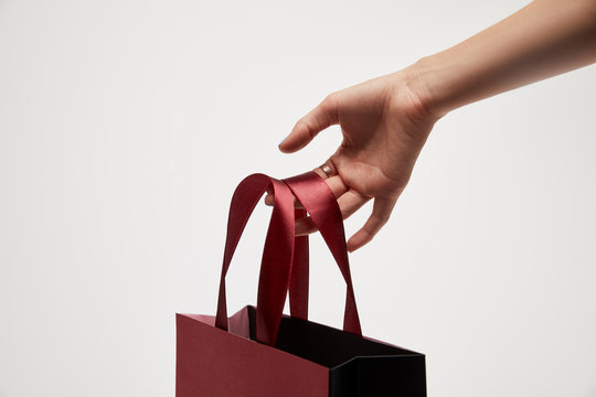 Cropped Image Of Woman Holding Red Shopping Bag In Hand Isolated On White