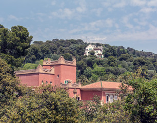 Obraz premium Red eighteenth century building of Baldiri Reixac school (former farmhouse residence of Count Guell), named Casa Larrard, and white Casa Trias in Park Guell, Barcelona, Spain.