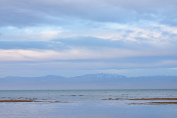 Scenic view of lake with grey mountains on horizon
