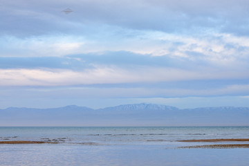 Scenic view of lake with grey mountains on horizon
