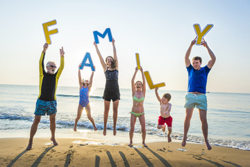 Obraz premium Family holding up letters at the beach