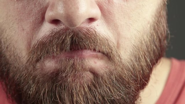 Angry nervous man close up. Furiously moving his mouth. Man with beard